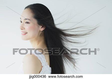 Stock Photograph - Young woman with fluttering hair smiling. Fotosearch