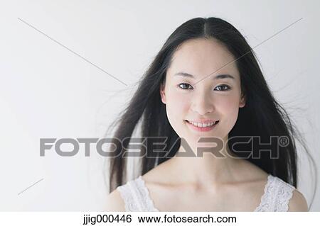 Young woman with fluttering hair smiling at camera View Large Photo Image Stock Photograph - Young woman with fluttering hair smiling at camera. Fotosearch