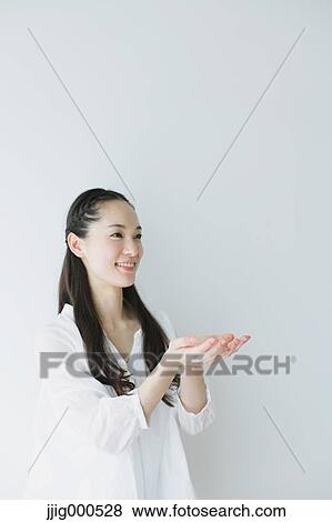 Stock Photo - Young woman with long hair raising arms. Fotosearch