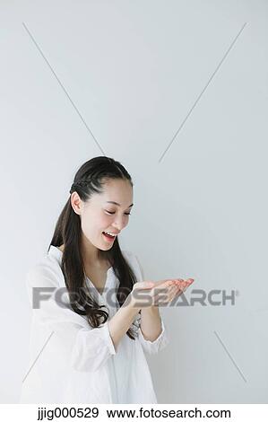 Stock Photo - Young woman with long hair raising arms. Fotosearch