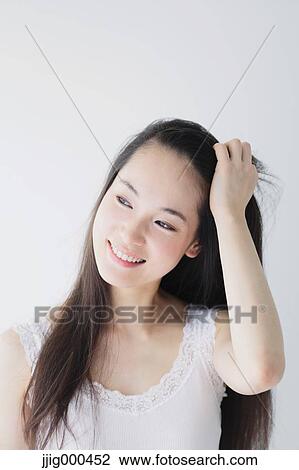 Stock Image - Young woman with long hair smiling. Fotosearch