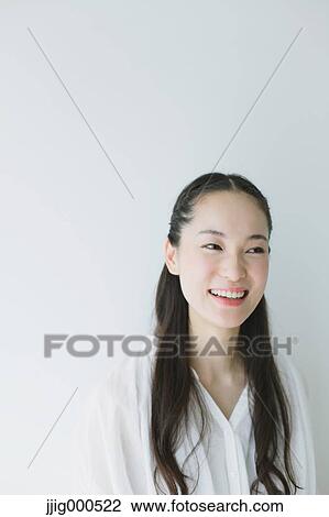 Stock Image - Young woman with long hair smiling. Fotosearch