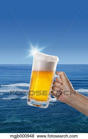 Glass of beer and sea in the background View Large Photo Image Stock Photo - Glass of beer and sea in the background. Fotosearch