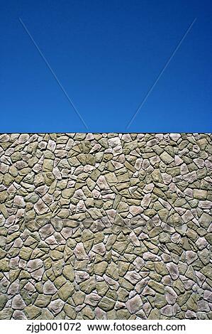 Stock Image - Stone wall and blue sky. Fotosearch