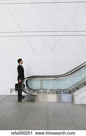 Businessman on escalator View Large Photo Image Stock Image - Businessman on escalator. Fotosearch