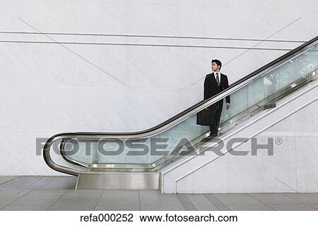 Businessman on escalator View Large Photo Image Stock Image - Businessman on escalator. Fotosearch
