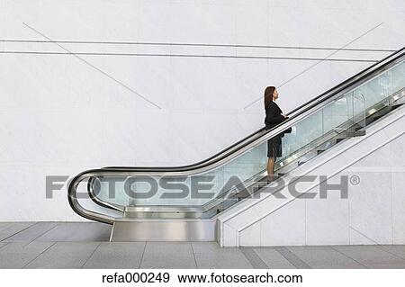 Businessman on escalator View Large Photo Image Stock Photo - Businessman on escalator. Fotosearch