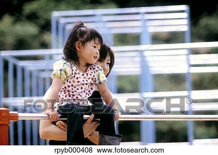 Stock Photo - Japanese mother and daughter at the park. Fotosearch