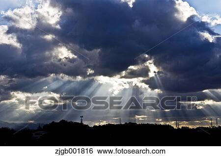 Stock Photograph - Shaft of light shining through clouds. Fotosearch