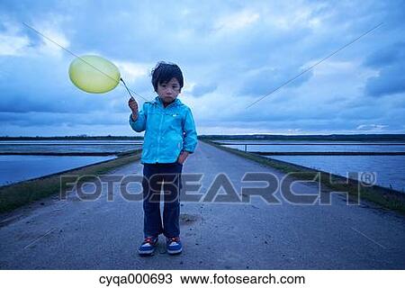 Stock Image - Japanese kid with balloon in the countryside. Fotosearch