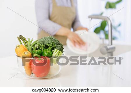 Woman washing dishes in the kitchen View Large Photo Image Stock Image - Woman washing dishes in the kitchen. Fotosearch