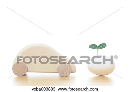 Stock Image - Wooden car and leaf sprouting from egg. Fotosearch