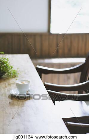 Cappuccino on wooden table in a cafe View Large Photo Image Picture - Cappuccino on wooden table in a cafe. Fotosearch