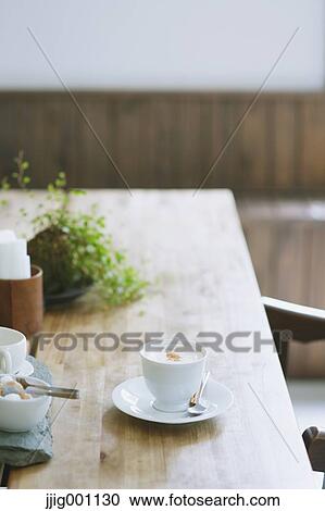 Cappuccino on wooden table in a cafe View Large Photo Image Stock Image - Cappuccino on wooden table in a cafe. Fotosearch