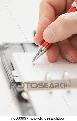 Close up of male hand writing on agenda View Large Photo Image Stock Photo - Close up of male hand writing on agenda. Fotosearch