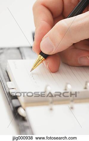 Close up of male hand writing on agenda View Large Photo Image Stock Photo - Close up of male hand writing on agenda. Fotosearch