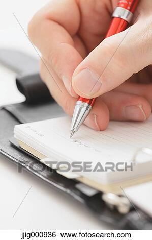 Close up of male hand writing on agenda View Large Photo Image Stock Photograph - Close up of male hand writing on agenda. Fotosearch