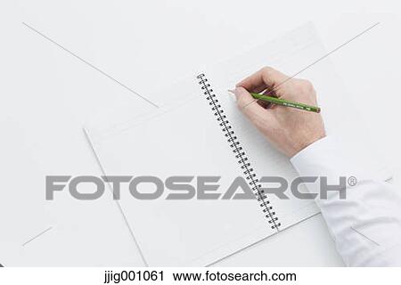 Stock Image - Close up of male hand writing on notebook. Fotosearch