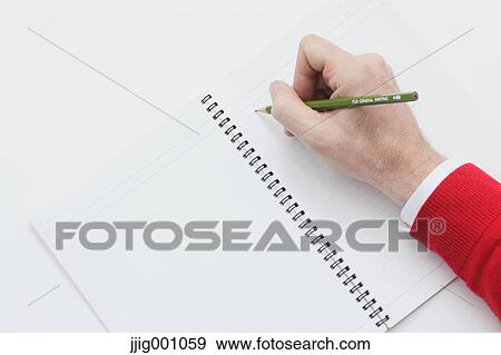 Stock Photo - Close up of male hand writing on notebook. Fotosearch