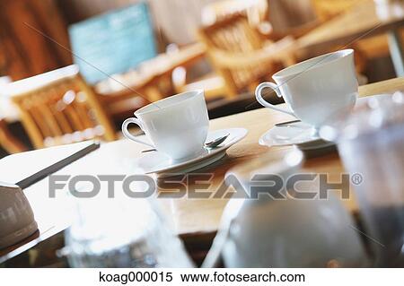 Coffee cups on wooden table in a cafe View Large Photo Image Stock Photography - Coffee cups on wooden table in a cafe. Fotosearch