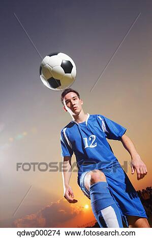 Football player in a blue uniform lifting ball View Large Photo Image Picture - Football player in a blue uniform lifting ball. Fotosearch