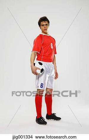 Football player in a white and red uniform standing against white background View Large Photo Image Picture - Football player in a white and red uniform standing against white background. Fotosearch