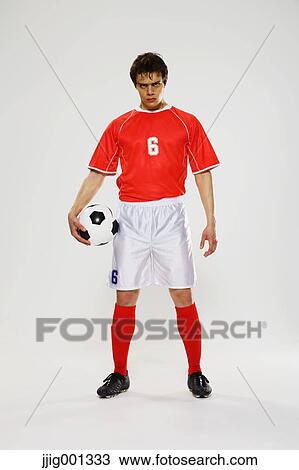 Football player in a white and red uniform standing against white background View Large Photo Image Stock Image - Football player in a white and red uniform standing against white background. Fotosearch