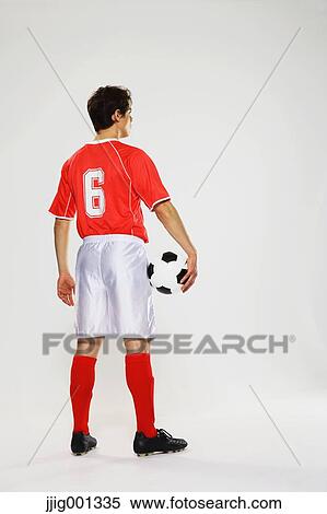 Football player in a white and red uniform standing against white background View Large Photo Image Stock Photography - Football player in a white and red uniform standing against white background. Fotosearch