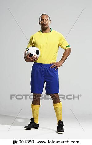 Football player in a yellow and blue uniform standing against white background View Large Photo Image Stock Image - Football player in a yellow and blue uniform standing against white background. Fotosearch