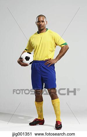 Football player in a yellow and blue uniform standing against white background View Large Photo Image Stock Image - Football player in a yellow and blue uniform standing against white background. Fotosearch