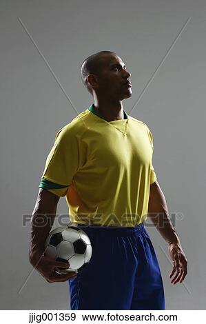 Football player in a yellow and blue uniform standing against grey background View Large Photo Image Stock Photo - Football player in a yellow and blue uniform standing against grey background. Fotosearch