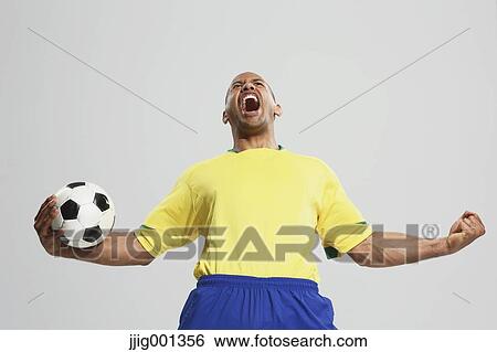 Football player in a yellow and blue uniform standing against white background View Large Photo Image Stock Photograph - Football player in a yellow and blue uniform standing against white background. Fotosearch