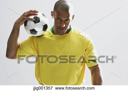 Football player in a yellow uniform standing against white background View Large Photo Image Stock Photo - Football player in a yellow uniform standing against white background. Fotosearch