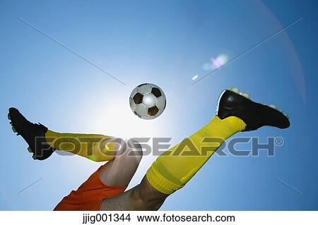 Football player kicking ball in mid-air View Large Photo Image Picture - Football player kicking ball in mid-air. Fotosearch