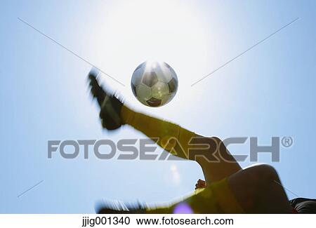 Football player kicking ball in mid-air View Large Photo Image Stock Image - Football player kicking ball in mid-air. Fotosearch
