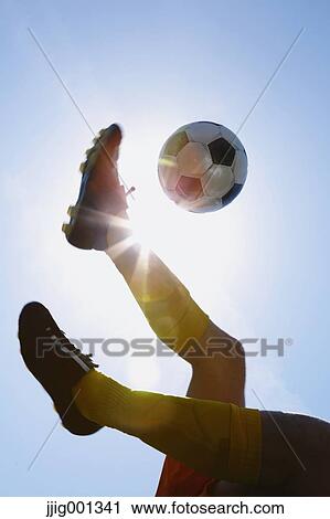 Football player kicking ball in mid-air View Large Photo Image Stock Image - Football player kicking ball in mid-air. Fotosearch