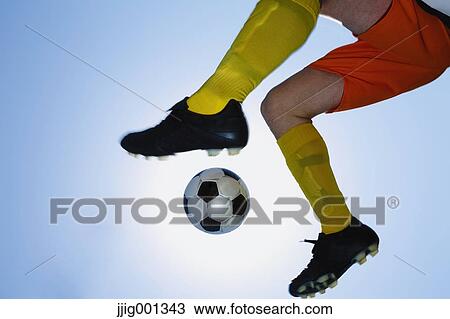 Football player kicking ball in mid-air View Large Photo Image Stock Image - Football player kicking ball in mid-air. Fotosearch