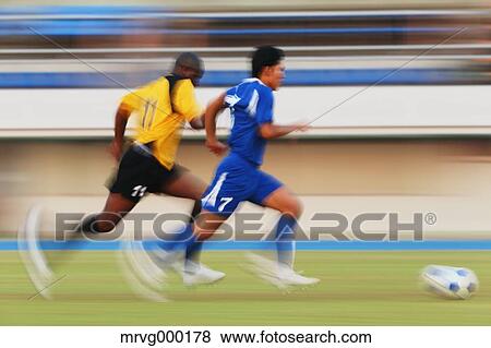 Stock Photo - Football players running with ball. Fotosearch