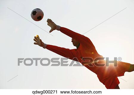 Goalkeeper in orange uniform catching the ball View Large Photo Image Stock Image - Goalkeeper in orange uniform catching the ball. Fotosearch