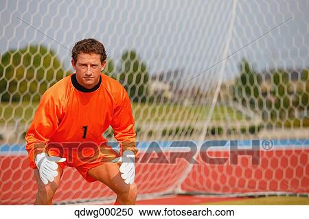 Goalkeeper in orange uniform standing in soccer field View Large Photo Image Stock Image - Goalkeeper in orange uniform standing in soccer field. Fotosearch