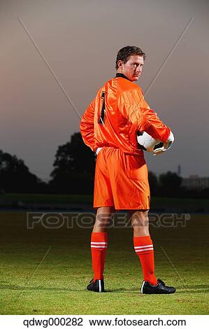 Goalkeeper in orange uniform standing in soccer field View Large Photo Image Stock Image - Goalkeeper in orange uniform standing in soccer field. Fotosearch