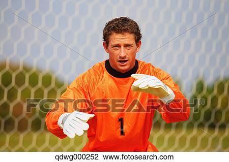 Stock Image - Goalkeeper in orange uniform. Fotosearch