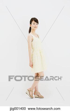 Japanese young woman in a one piece dress standing against white background View Large Photo Image Stock Image - Japanese young woman in a one piece dress standing against white background. Fotosearch