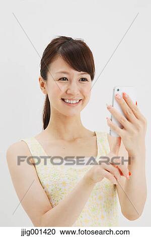 Japanese young woman in a one piece dress with smartphone against white background View Large Photo Image Stock Image - Japanese young woman in a one piece dress with smartphone against white background. Fotosearch