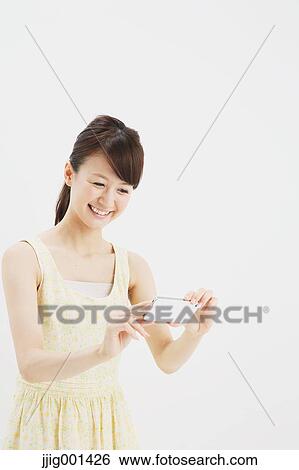 Japanese young woman in a one piece dress with smartphone against white background View Large Photo Image Stock Photograph - Japanese young woman in a one piece dress with smartphone against white background. Fotosearch