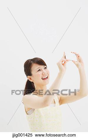 Japanese young woman in a one piece dress with smartphone against white background View Large Photo Image Stock Photography - Japanese young woman in a one piece dress with smartphone against white background. Fotosearch