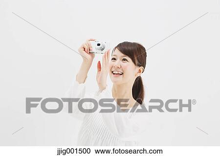 Japanese young woman in a white shirt with digital camera against white background View Large Photo Image Stock Image - Japanese young woman in a white shirt with digital camera against white background. Fotosearch