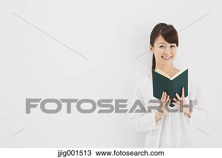 Japanese young woman in a white shirt with a book against white background View Large Photo Image Stock Image - Japanese young woman in a white shirt with a book against white background. Fotosearch