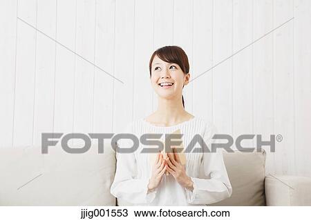 Japanese young woman in a white shirt with a book on the sofa View Large Photo Image Stock Image - Japanese young woman in a white shirt with a book on the sofa. Fotosearch