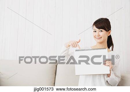 Japanese young woman in a white shirt with sketchbook on the sofa View Large Photo Image Stock Image - Japanese young woman in a white shirt with sketchbook on the sofa. Fotosearch